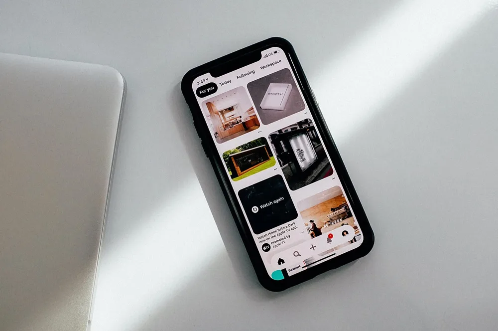 Smartphone met de Pinterest-app open op een witte tafel